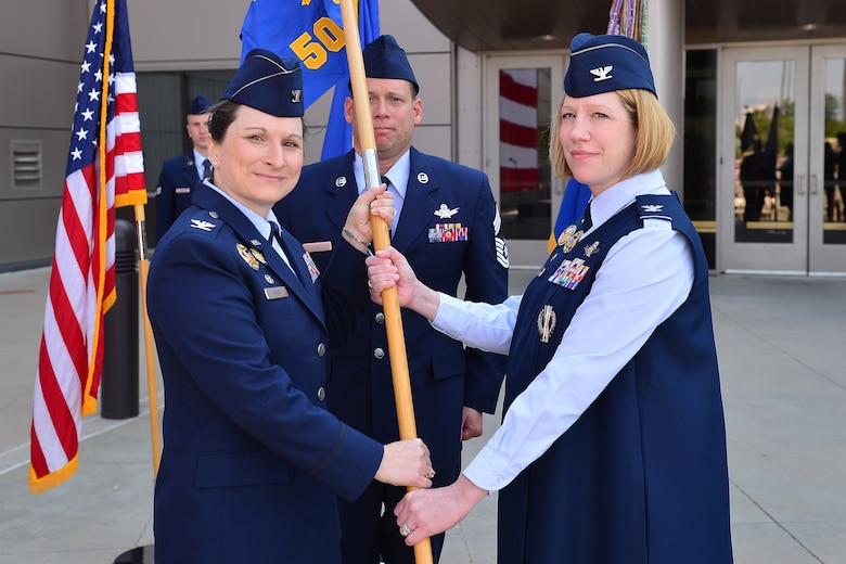 Col. Jennifer Grant, commander of the 50th Space Wing, hands the 50th Operations Group guidon to Col. Laurel Walsh, new commander of the 50th OG at a change of command ceremony at Schriever Air Force Base, Colorado, June 15, 2018. Walsh comes to Schriever AFB after serving as the military assistant to the Chief of Staff to the Secretary of Defense. (U.S. Air Force photo by Dennis Rogers)