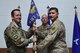 two airmen pose for a photo holding a guidon