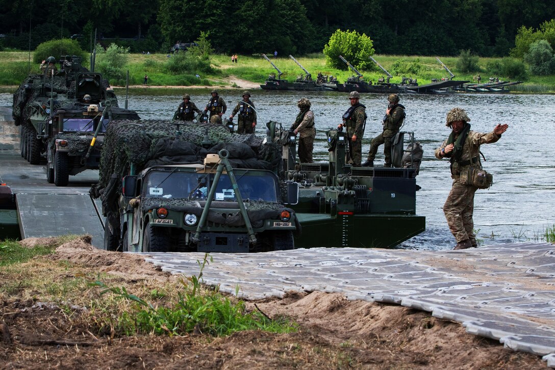 After ferrying across the Nemen River, troops embark on a temporary driving surface.