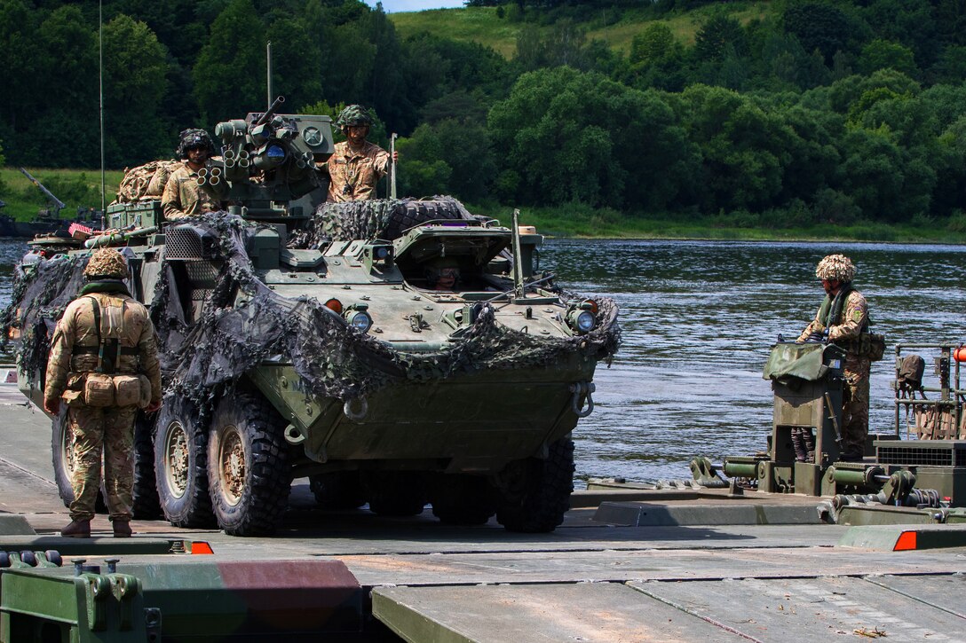 Soldiers assigned to the 2nd Cavalry Regiment unload their Stryker from an M3 Amphibious Rig Bridge.