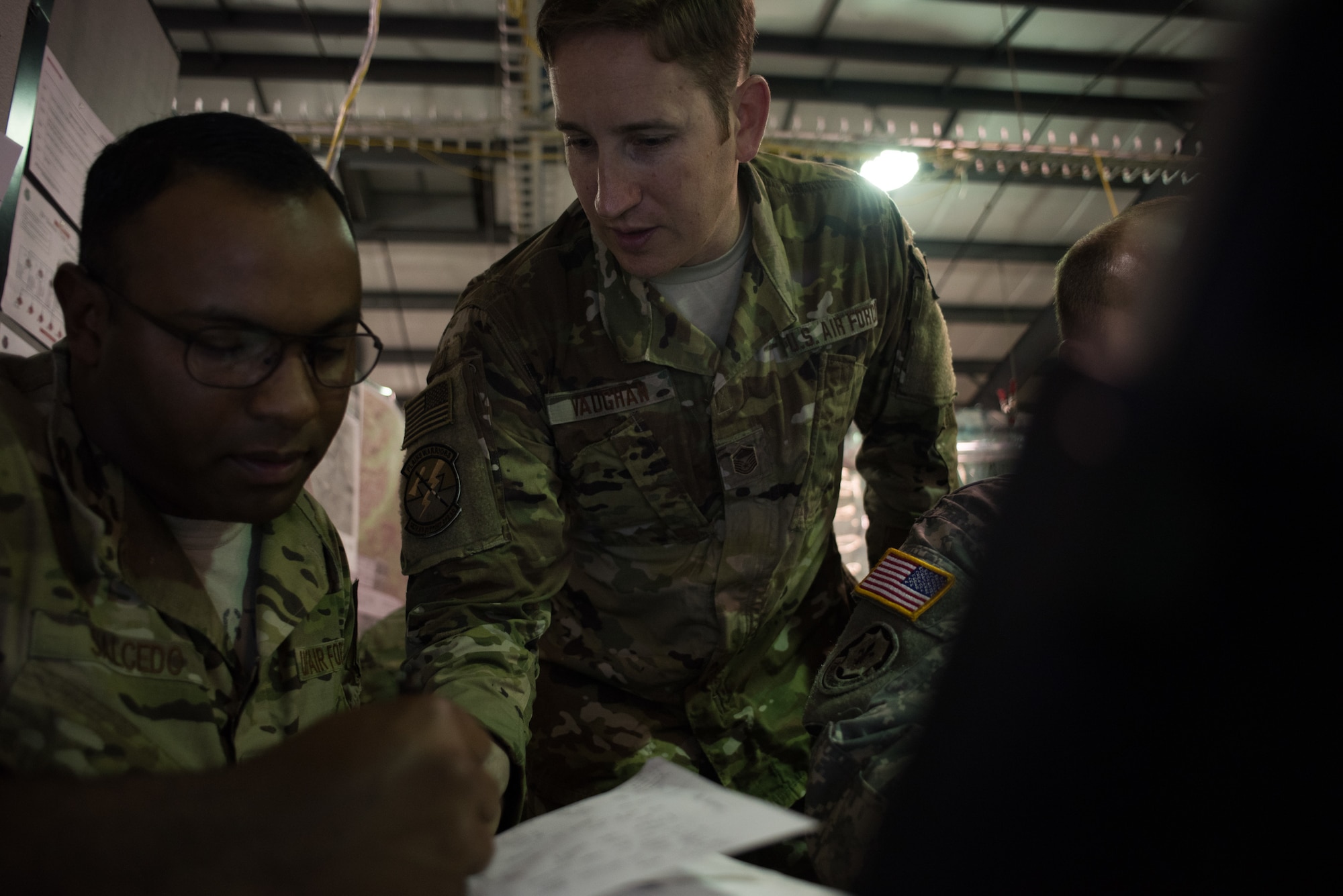 Master Sgt. Christopher Vaughn, 146th Air Support Operations Squadron (146th ASOS) tactical air control party (TACP) non-commissioned officer in charge, looks at notes with Staff Sgt. Samuel Salcedo, 146th ASOS TACP specialist, after receiving information during a combat scenario during Warfighter 18-5 (WFX-18-5) June 10, 2018, at Camp Atterbury Joint Maneuver Training Center near Edinburgh, Indiana. WFX-18-5 was conducted to help components under the 34th Infantry Division become accustomed to using Army battle drills in a computer-simulated combat environment. (U.S. Air National Guard photo by Staff Sgt. Brigette Waltermire)