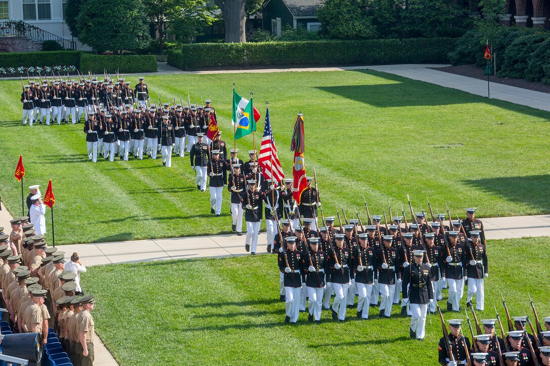 Marines with Marine Barracks Washington D.C. execute pass and review during  a Troop Review Ceremony to honor military officials from Brazil and Mexico at the Barracks, June 18, 2018. The Barracks hosted our Brazilian and Mexican military counterparts to honor Commandant of the Brazil Corps of Naval Infantry, Adm. Alexandre Jose Barreto de Mattos, and Coordinator General, Mexico Naval Infantry, Vice Adm. Rafael Lopez Martinez. (Official Marine Corps photo by Sgt. Robert Knapp/Released)