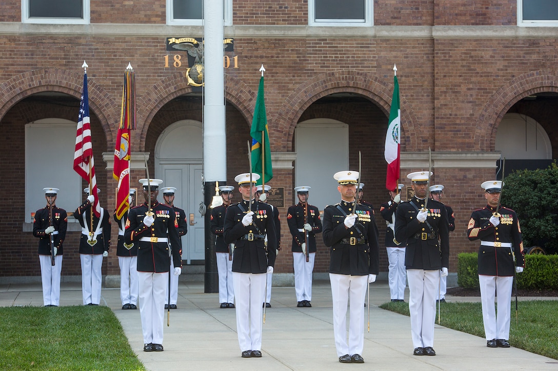 Marines with the Marine Barracks Washington D.C. parade marching staff render honors to military officials from Brazil and Mexico during a Troop Review Ceremony at the Barracks, June 18, 2018. The Barracks hosted our Brazilian and Mexican military counterparts for to honor Commandant of the Brazil Corps of Naval Infantry, Adm. Alexandre Jose Barreto de Mattos, and Coordinator General, Mexico Naval Infantry, Vice Adm. Rafael Lopez Martinez. (Official Marine Corps photo by Sgt. Robert Knapp/Released)