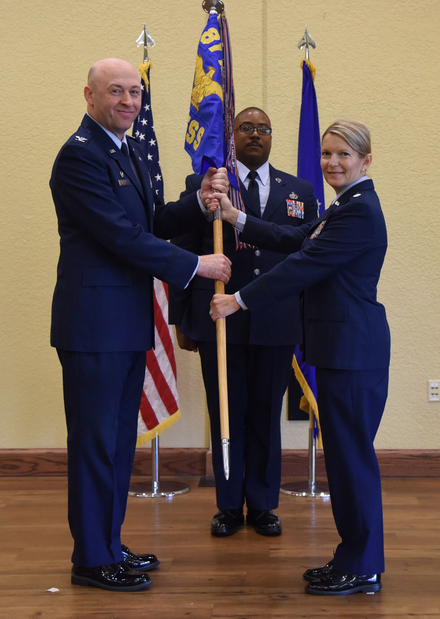 U.S. Air Force Col. Danny Davis, 81st Mission Support Group commander, takes the 81st Force Support Squadron guidon from Lt. Col. Teresa Ammons, outgoing 81st FSS commander, during the 81st FSS change of command ceremony in the Bay Breeze Event Center at Keesler Air Force Base, Mississippi, June 14, 2018. The passing of the guidon is a ceremonial symbol of exchanging command from one commander to another. (U.S. Air Force photo by Kemberly Groue)