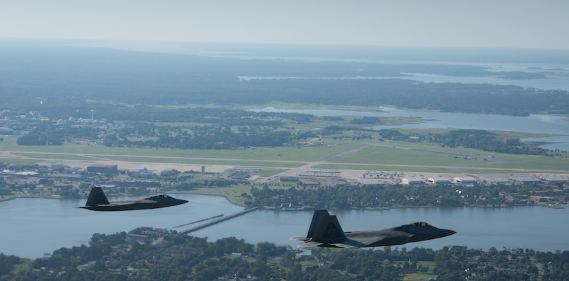 Two U.S. Air Force F-22 Raptors fly over their home-wing, the 1st Fighter Wing at Joint Base Langley-Eustis, Virginia, June 14, 2018.