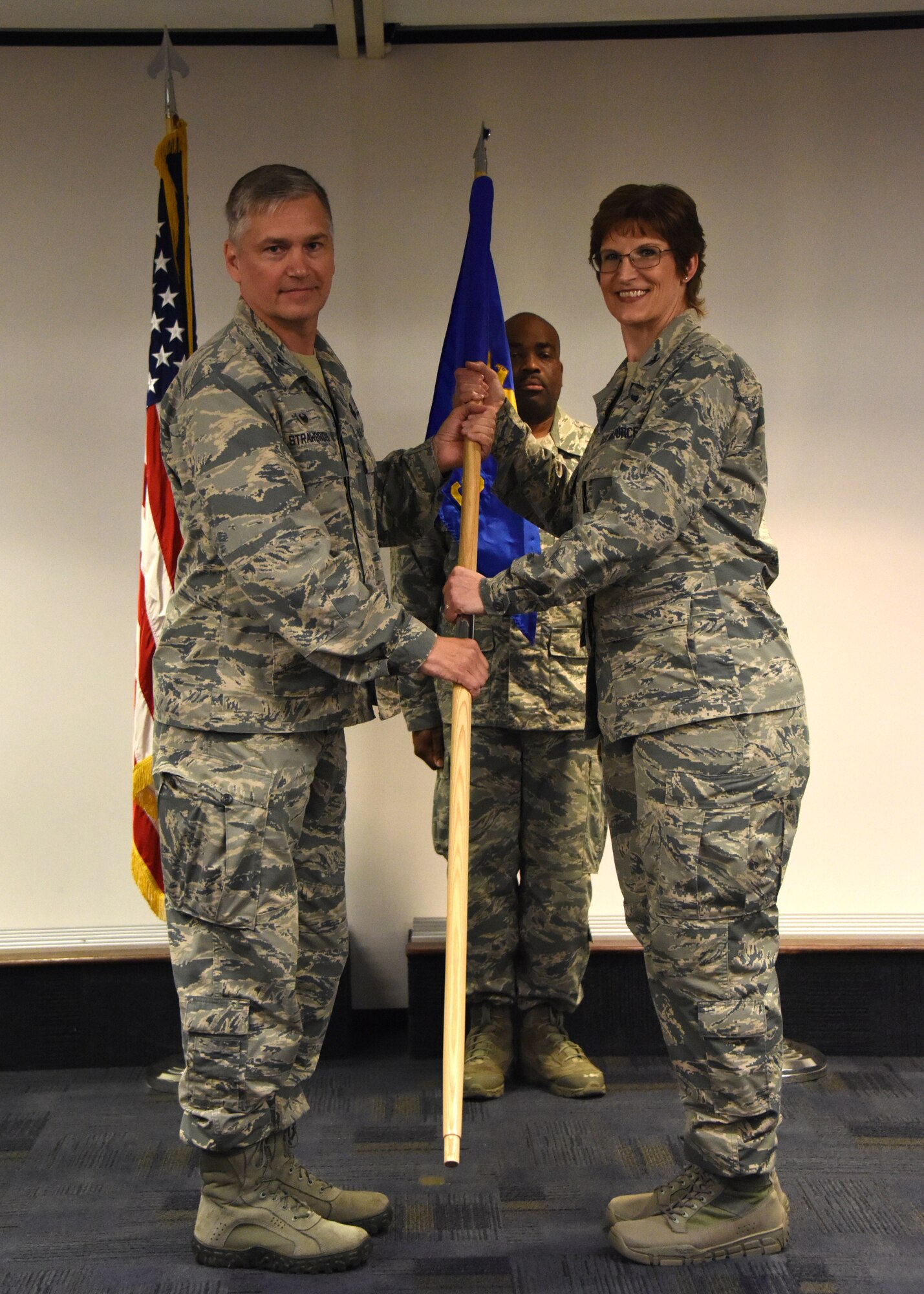 Col. Douglas Strawbridge, commander of the 911th Airlift Wing , and Col. Karen Steiner, commander of the 911th Aeromedical Staging Squadron , pass the flag at the assumption of command ceremony at the Pittsburgh International Airport Air Reserve Station, Pennsylvania June 2, 2018. This act symbolizes that Steiner is assuming responsibility for the 911th Aeromedical Staging Squadron. (U.S. Air Force Photo by Senior Airman Grace Thomson)