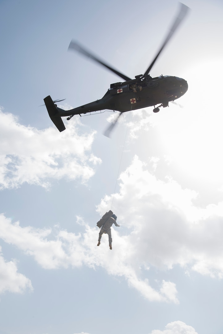 A soldier from Texas Army National Guard Company C, 2-149 Aviation is hoisted up to a UH-60 Black Hawk during Operation Lone Star Vigilance June 10, 2018, at Joint Base San Antonio-Camp Bullis, Texas. Operation Lone Star Vigilance was a joint-training exercise involving Active-Duty and Reserve Airmen and Soldiers from the Texas Army National Guard from installations across San Antonio. The multi-service missions saw the successful completion of aerial reconnaissance, sling loading of cargo, MEDEVAC hoists, personnel recovery and the simultaneous operation of multiple helicopter landing zones. (U.S. Air Force photo by Airman Shelby Pruitt)