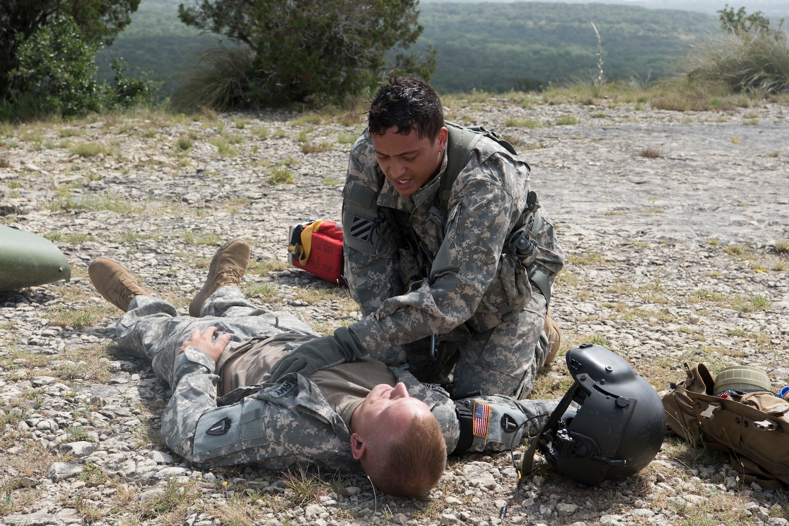 A Soldier from Texas Army National Guard Company C, 2-149 Aviation performs a medical evaluation on a downed pilot during Operation Lone Star Vigilance June 10, 2018, at Joint Base San Antonio-Camp Bullis, Texas. Operation Lone Star Vigilance was a joint-training exercise involving Active-Duty and Reserve Airmen and Soldiers from the Texas Army National Guard from installations across San Antonio. The multi-service missions saw the successful completion of aerial reconnaissance, sling loading of cargo, MEDEVAC hoists, personnel recovery and the simultaneous operation of multiple helicopter landing zones. (U.S. Air Force photo by Airman Shelby Pruitt)