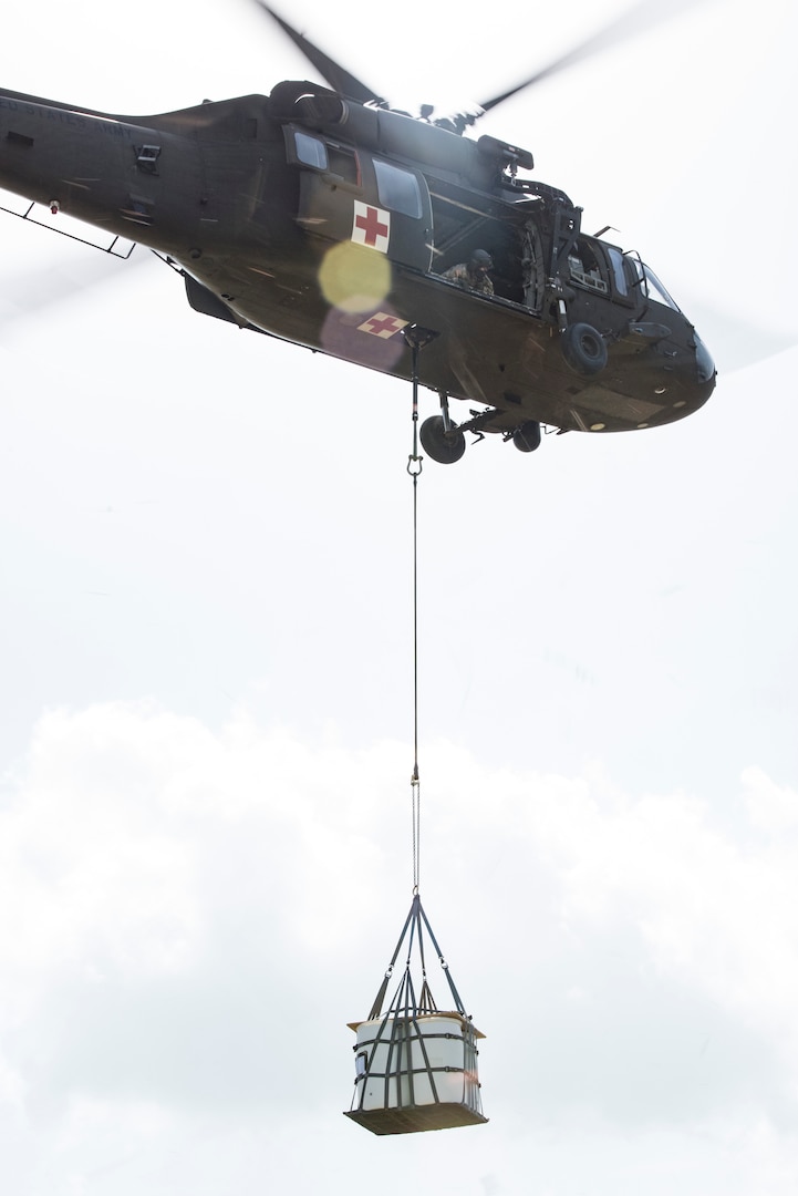 Soldiers of Texas Army National Guard Company C, 2-149 Aviation, air lift an A-22 cargo bag with 2,000 pounds of “relief supplies” beneath a UH-60 Black Hawk as part of Operation Lone Star Vigilance, June 10, 2018, at Joint Base San Antonio-Camp Bullis, Texas. Operation Lone Star Vigilance was a joint-training exercise involving Active-Duty and Reserve Airmen and Soldiers from the Texas Army National Guard from installations across San Antonio. The multi-service missions saw the successful completion of aerial reconnaissance, sling loading of cargo, MEDEVAC hoists, personnel recovery and the simultaneous operation of multiple helicopter landing zones. (U.S. Air Force photo by Senior Airman Stormy Archer)