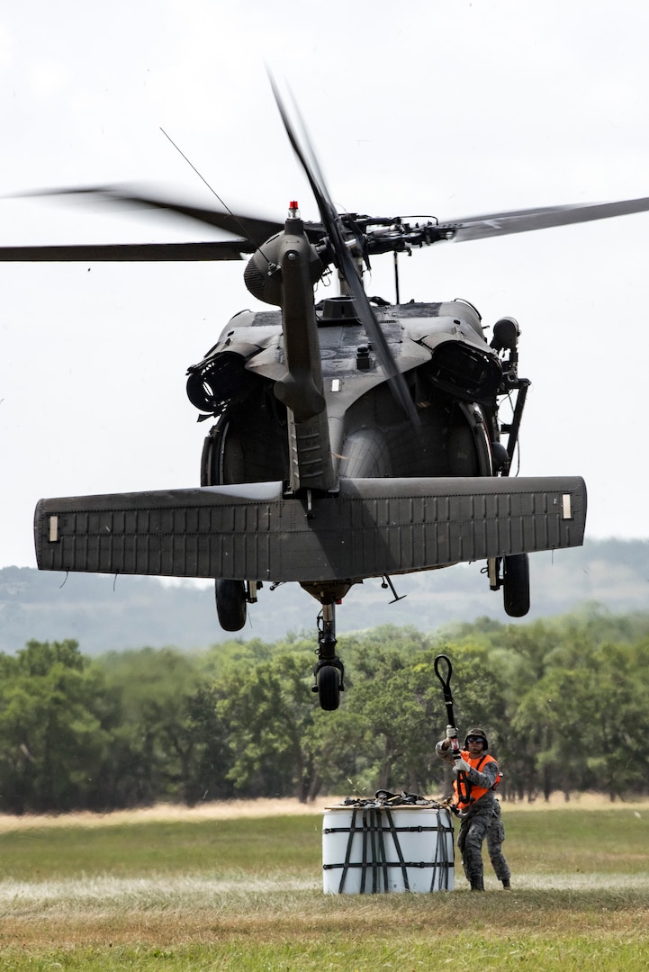 An Airman from the 26th Aerial Port Squadron prepares to hook 2,000 pounds of “relief supplies” to a UH-60 Black Hawk helicopter flown by a Soldier from Texas Army National Guard Company C, 2-149 Aviation, as part of a sling load mission during Operation Lone Star Vigilance June 10, 2018, at Joint Base San Antonio-Camp Bullis, Texas. Operation Lone Star Vigilance was a joint-training exercise involving Active-Duty and Reserve Airmen and Soldiers from the Texas Army National Guard from installations across San Antonio. The multi-service missions saw the successful completion of aerial reconnaissance, sling loading of cargo, MEDEVAC hoists, personnel recovery and the simultaneous operation of multiple helicopter landing zones. (U.S. Air Force photo by Senior Airman Stormy Archer)