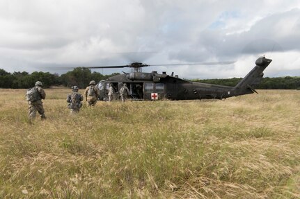Soldiers from Texas Army National Guard Company C, 2-149 Aviation runs back to a UH-60 Black Hawk helicopter after completing a personnel recovery mission during Operation Lone Star Vigilance June 15, 2018, at Joint Base San Antonio-Camp Bullis, Texas. Operation Lone Star Vigilance was a joint-training exercise involving Active-Duty and Reserve Airmen and Soldiers from the Texas Army National Guard from installations across San Antonio. The multi-service missions saw the successful completion of aerial reconnaissance, sling loading of cargo, MEDEVAC hoists, personnel recovery and the simultaneous operation of multiple helicopter landing zones. (U.S. Air Force photo by Airman Shelby Pruitt)