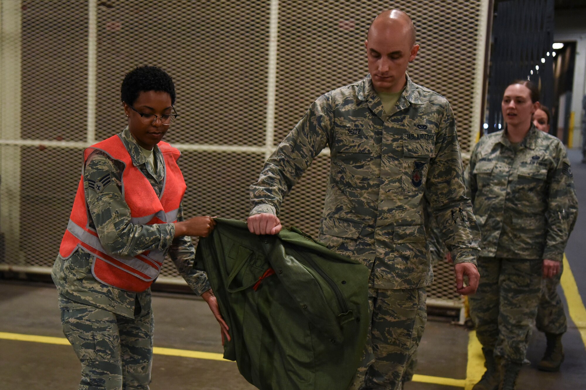 Senior Airman Shalice Chambers, a 319th Logistics Readiness Squadron equipment journeyman, assists in a readiness exercise June 14, 2018, on Grand Forks Air Force Base, North Dakota. Chambers ensured all Airmen had the proper deployment bad for the exercise. (U.S. Air Force photo by Airman 1st Class Melody K. Wolff)