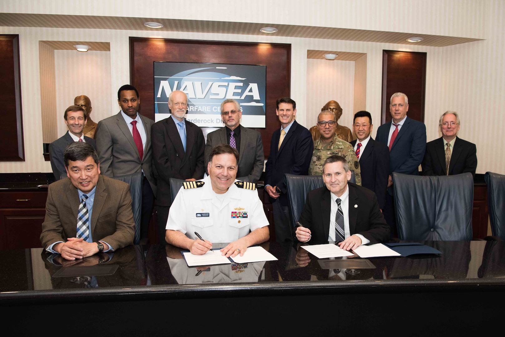 Naval Surface Warfare Center, Carderock Division Commanding Officer Capt. Mark Vandroff (center) and Technical Director (acting) Dr. Paul Shang (left) sign an Education Partnership Agreement with Dr. J. Scott Cameron (right) president of the National Intelligence University, in West Bethesda, Md., June 11, 2018. (Seated from left) Shang, Vandroff and Cameron. (Standing from left) Carderock Marine and Aviation Division Head Steve Ebner (Code 88), Carderock Patent Attorney Dave Ghatt, Carderock Director of Strategic Relations Dr. John Barkyoumb, NIU Professor Dr. Peter Leitner, NIU Dean of the School of Science and Technology Intelligence Dr. Brian Holmes, NIU faculty member MSG Angel Morales, Carderock Electrical Engineer Dr. Peter Cho (Code 88), Department Head Naval Architecture and Engineering Mike Brown and Carderock Director of Technology Transfer Dr. Joseph Teter (Code 00T). (U.S. Navy photo by Nicholas Brezzell/Released)