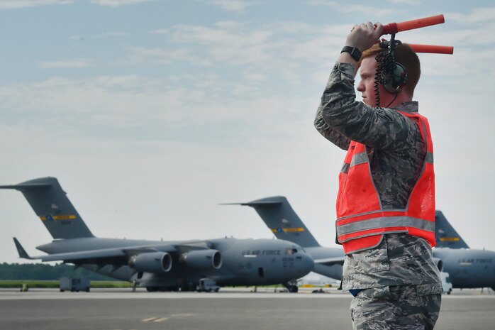 Airman 1st Class Andrew Causey, 437th Aircraft Maintenance Squadron crew chief, marshals out a C-17 Globemaster III June 14, 2018, at Joint Base Charleston, S.C. Crew chiefs here are responsible for coordinating the care and maintenance of one of the largest fleets of C-17 aircraft in the Air Force in support of Air Mobility Command’s rapid global mobility mission.