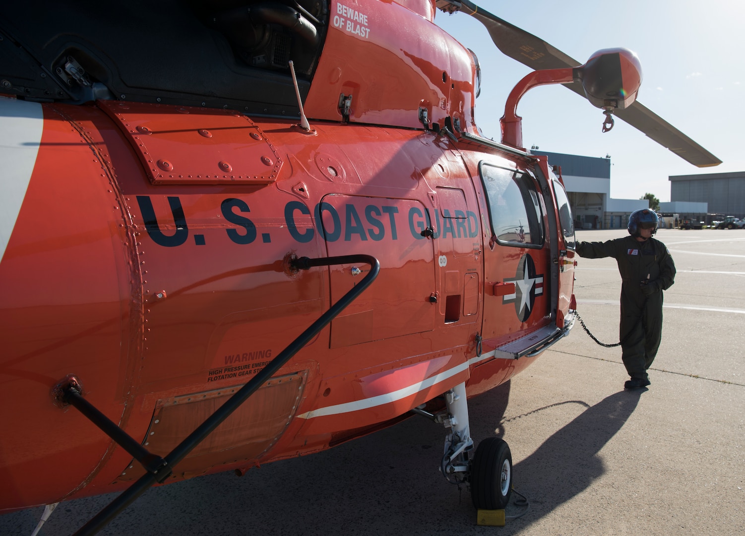 A U.S. Coast Guardsman leans on a HH-65 Dolphin during a forward air-refueling point on Coast Guard Air Station Atlantic City, N.J., June 14, 2018. An HH-65 was successfully refueled from a Marine Medium Tilt Roader Squadron (VMM) 774 V-22 Osprey for the first time in hopes of implementing the forward air-refueling point in future missions. (U.S. Air Force photo by Airman Ariel Owings)