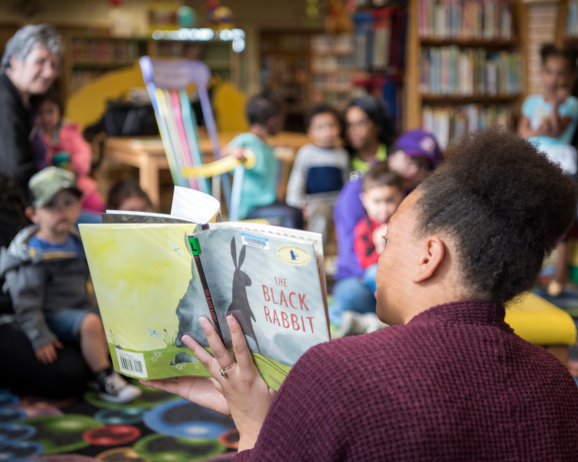 Children listen to a story read by Chaunice Carr, a summer library intern, during a reading time at the Joint Base Elmendorf-Richardson Library, June 13, 2018. The library is hosting weekly events through July 2018, to coincide with this year’s Summer Reading Program “Reading Takes You Everywhere.” The program offers individuals the opportunity to collect prizes for time spent reading or being read to.