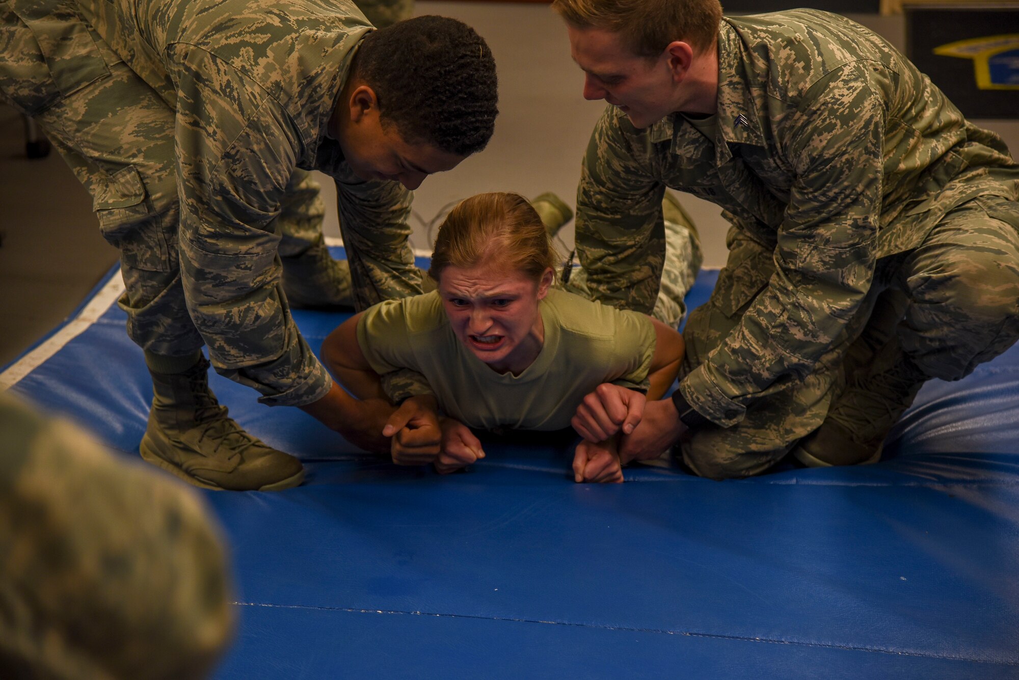 Cadet 2nd Class Isaiah Sanders, right, and Cadet 2nd Class Ben Pagel, left, restrain Cadet 2nd Class Jessica Frederick, middle, while being tased during a security forces demonstration at Misawa Air Base, Japan, June 18, 2018. Before their junior year at the United States Air Force Academy, cadets visit an active duty Air Force base to learn more about the operational Air Force and its career fields. (U.S. Air Force photo by Airman 1st Class Collette Brooks)