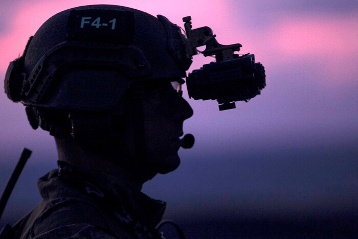The profile of a Marine's head against a purple and red sky.