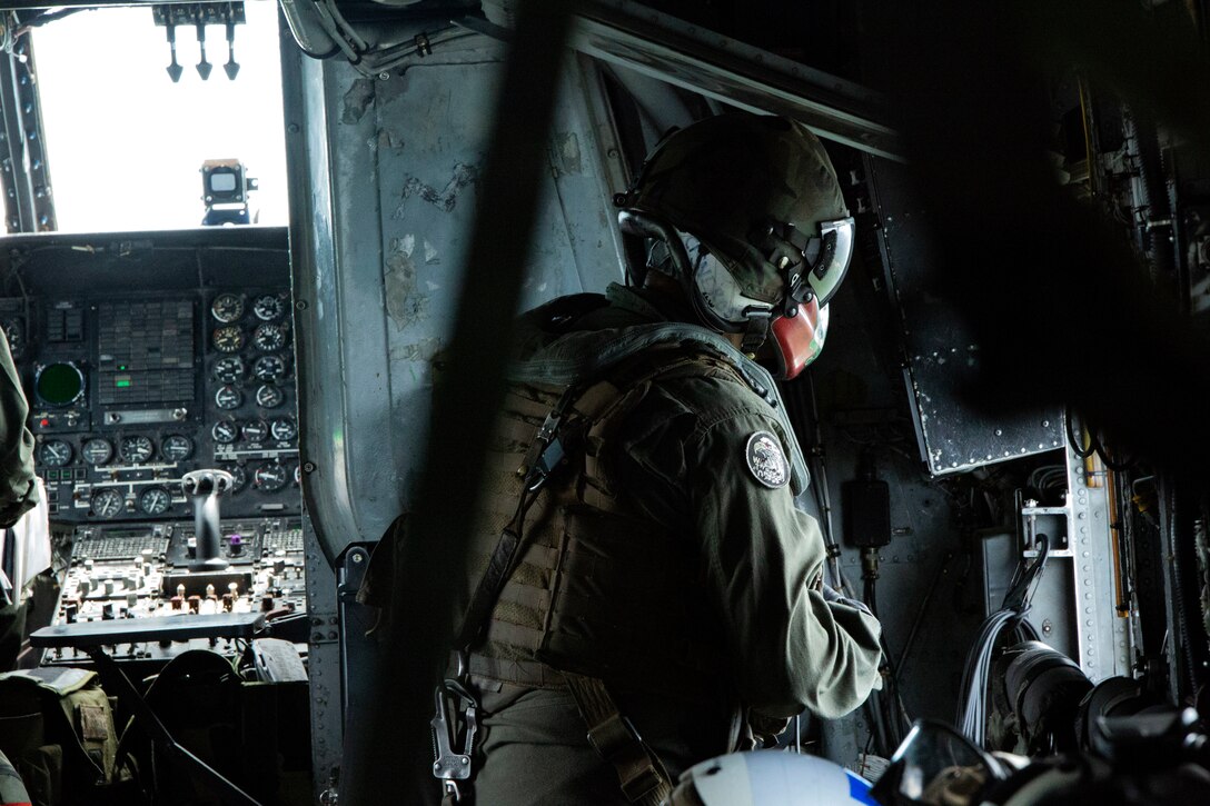 U.S. Marine Cpl. Christian P. Cisneros, a CH-53E Super Stallion crew chief with Special Purpose Marine Air-Ground Task Force - Southern Command, surveys the local area during a flight near Puerto Castilla, Honduras, June 18, 2018. The Marines and sailors of SPMAGTF-SC are conducting security cooperation training and engineering projects alongside partner nation military forces in Central and South America. The unit is also on standby to provide humanitarian assistance and disaster relief in the event of a hurricane or other emergency in the region.