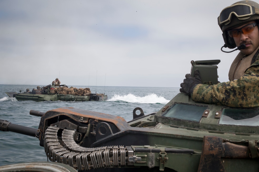 U.S. Marine Sgt. Bryan Perdigon, an assault amphibian Marine with Battalion Landing Team 3/1, 13th Marine Expeditionary Unit, surveys the sea from his turret while at sea, June 13, 2018. The Essex Amphibious Ready Group and 13th MEU are conducting Composite Training Unit Exercise, the final exercise before the units’ upcoming deployment. This exercise validates the ARG/MEU team’s ability to adapt and execute missions in ever-changing, unknown environments. Upon completion of COMPTUEX, the 13th MEU and Essex ARG will be certified as the nation’s premier forward-deployed, crisis response force, capable of executing missions across the broad spectrum of military operations.