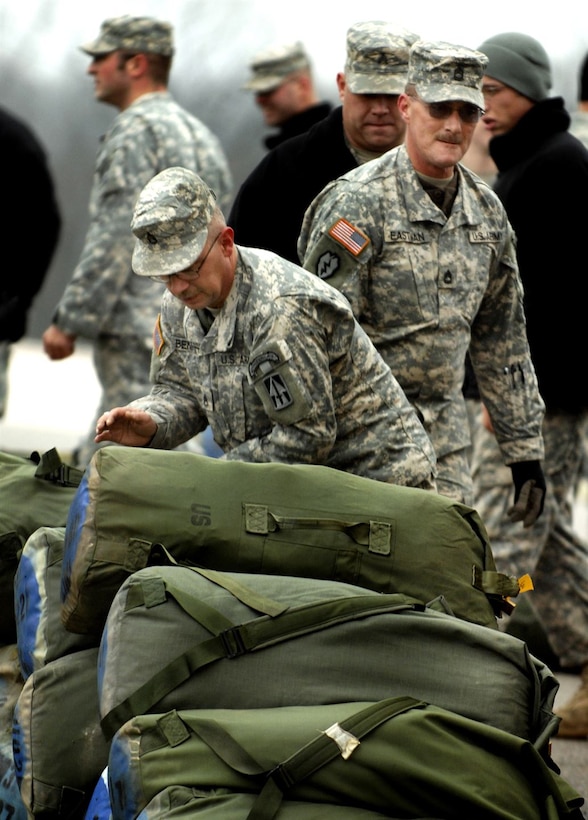 Members of the 76th Infantry Brigade Combat Team are pictured unloading duffle bags at Camp Atterbury Joint Maneuver Training Center in Edinburgh, Ind.