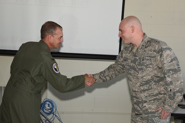 Col. Troy Henderson, the Air Combat Command (ACC) inspector general team chief, left, shakes hands and presents the prestigious inspector general’s coin to 2nd Lt. Michael Schuldt, of the 119th Logistics Readiness Squadron, for Schuldt’s exceptional performance during a unit effectiveness inspection (UEI) at the North Dakota Air National Guard Base, Fargo, N.D., May 20, 2018.