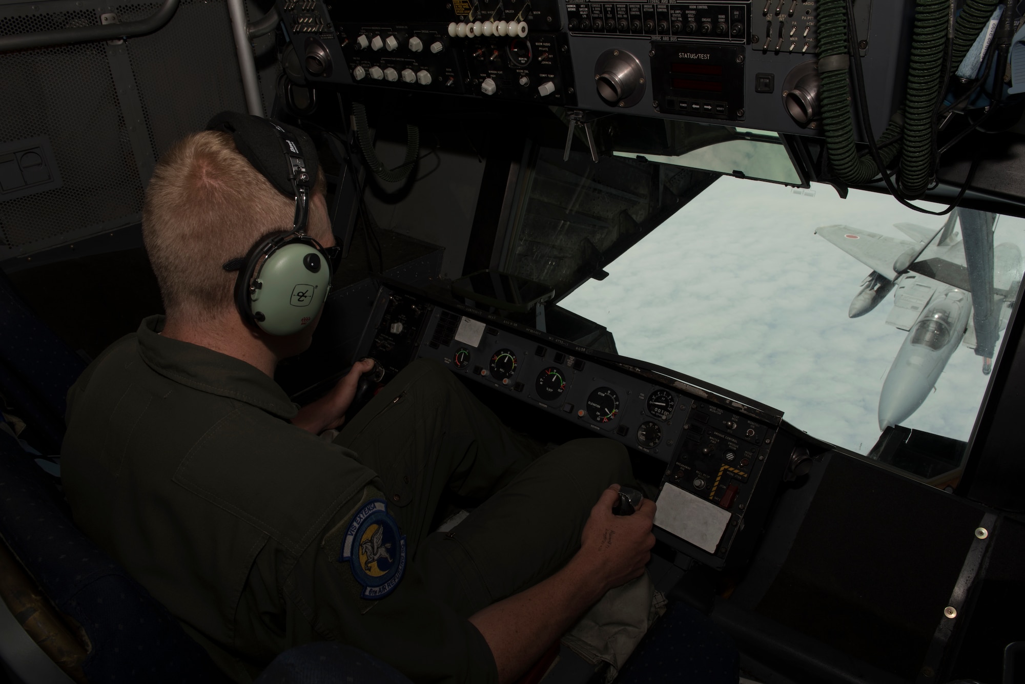 U.S. Air Force Staff Sgt. Zachariah Ploeger, 6th Air Refueling Squadron boom operator, refuels an F-15 during a mission in the Pacific theater June 4, 2018. The boom operator is responsible for ensuring safe refueling with receiver aircraft thousands of feet above the ground. Ploeger refueled eight fighter aircraft from the United States and Japan during the five-day mission. (U.S. Air Force photo by Tech. Sgt. James Hodgman)