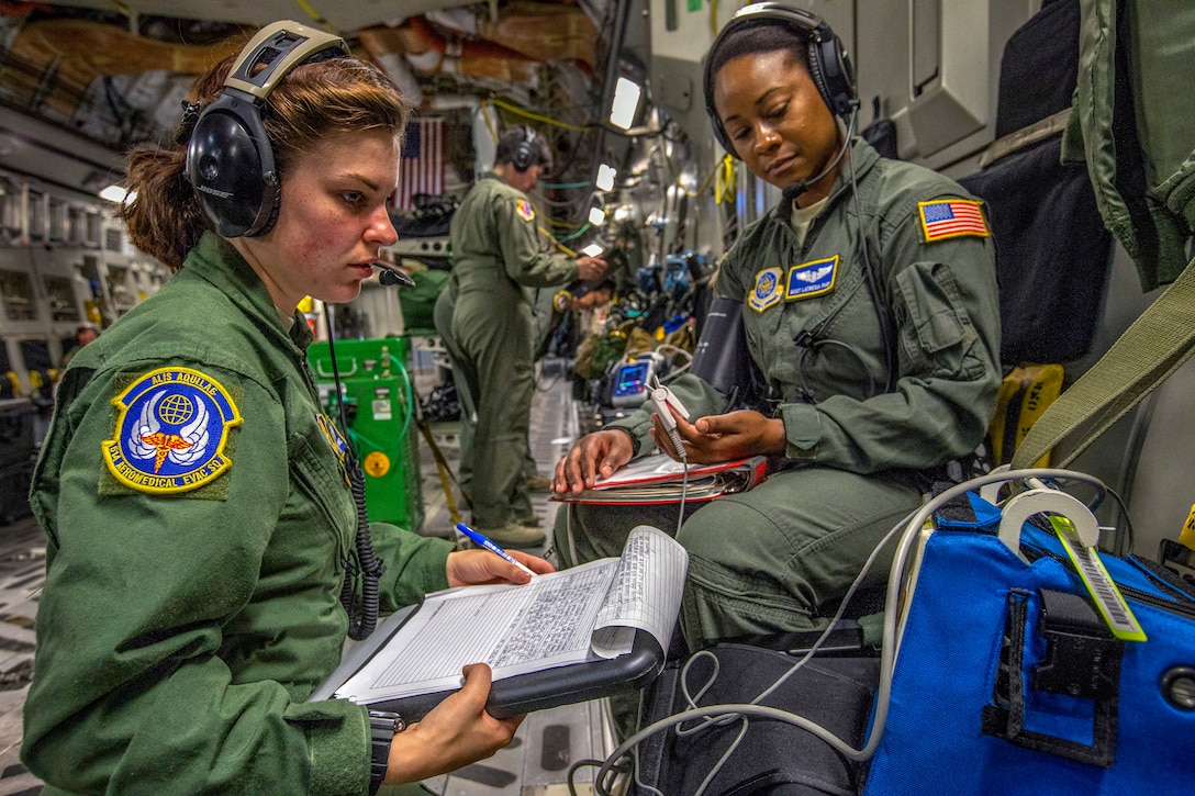 An airman checks the blood pressure of another airman.