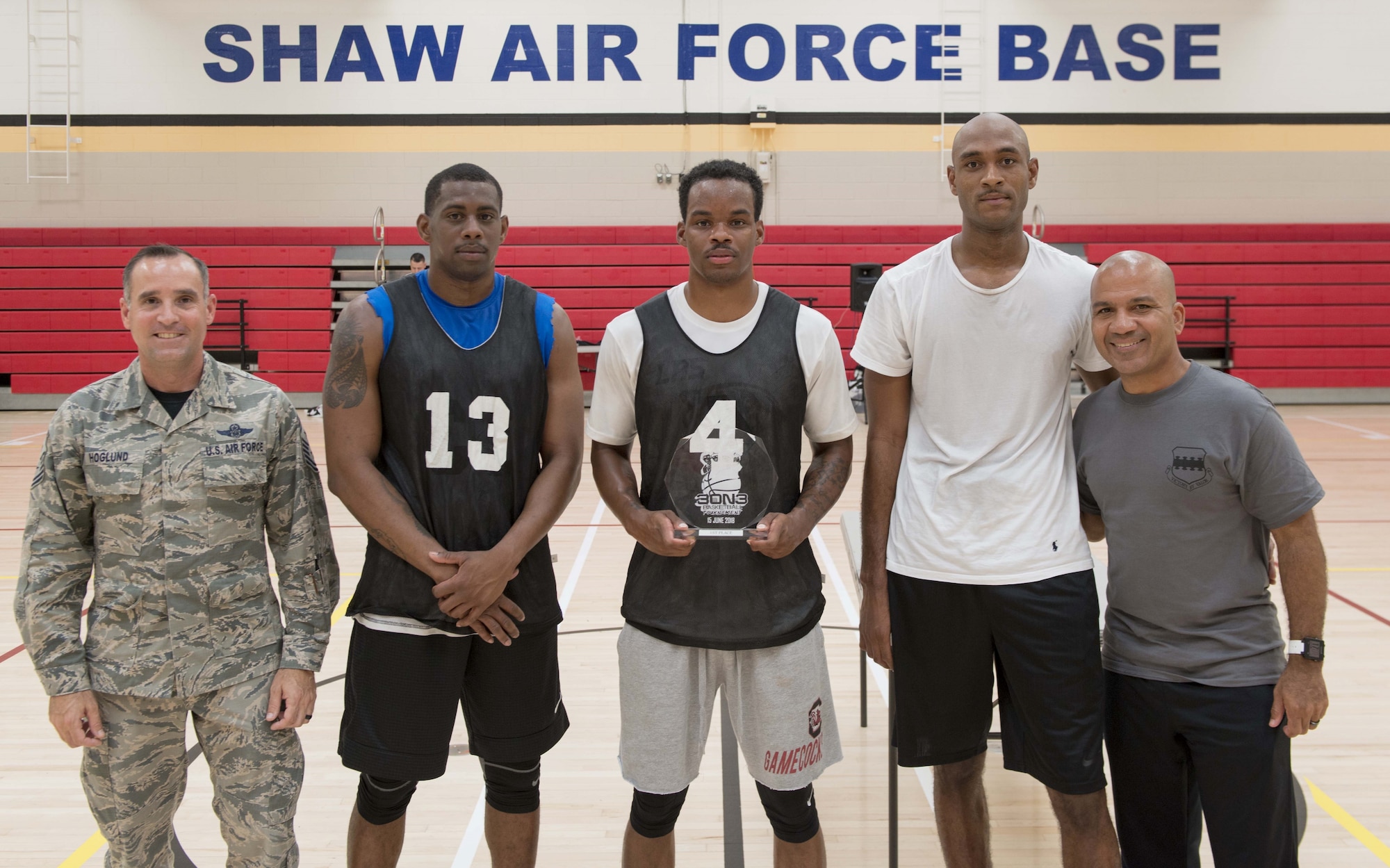 U.S. Air Force Chief Master Sgt. Daniel Hoglund, 20th Fighter Wing command chief, far left, and Chaplain (Capt.) Eddie Rubero, 20th Fighter Wing chaplain, far right, recognize Airmen from the 20th Logistics Readiness Squadron at Shaw Air Force Base, S.C., June 15, 2018 for winning the Four Chaplains 3-on-3 Basketball Tournament.