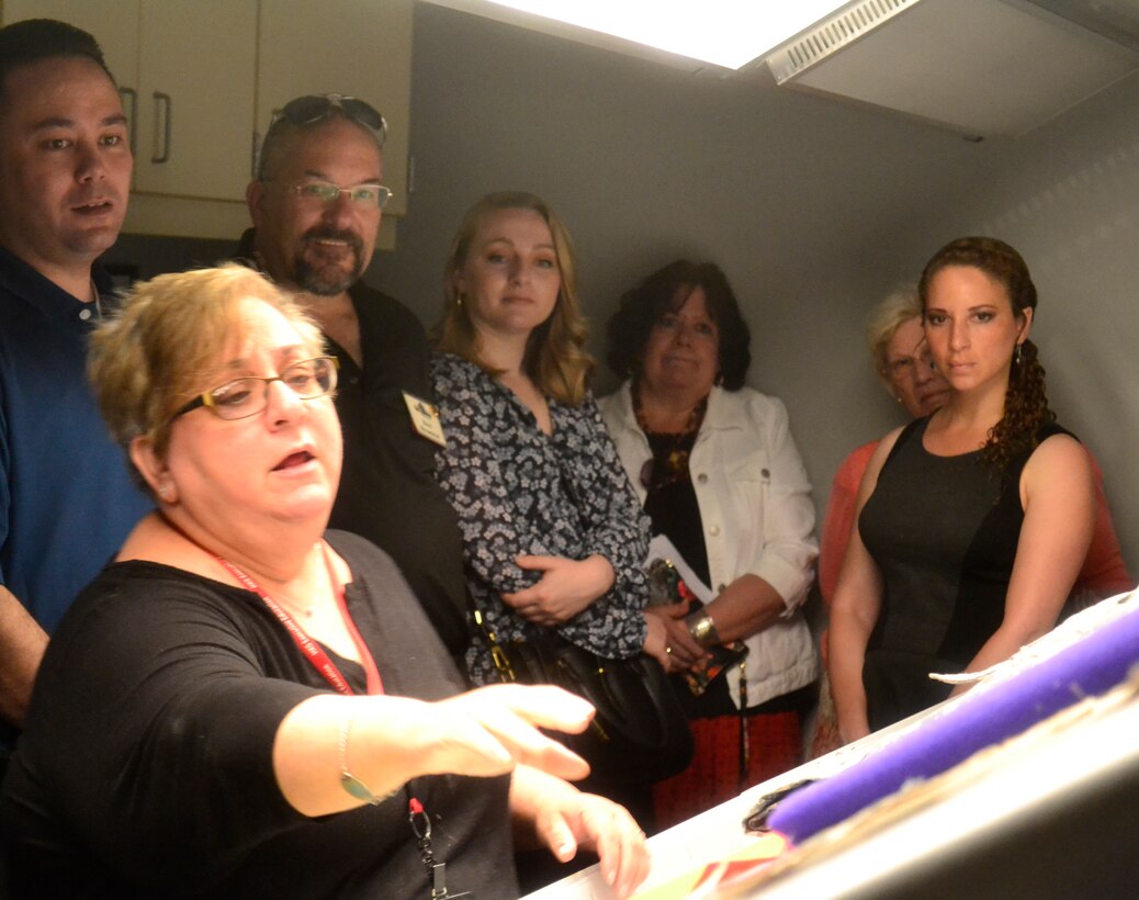 Members of the Greater Northeast Philadelphia Chamber of Commerce listen as Defense Logistics Agency Troop Support's Product Test Center Analytical supervisor Jamie Hieber provides a tour of the test center's shade room in Philadelphia June 18.