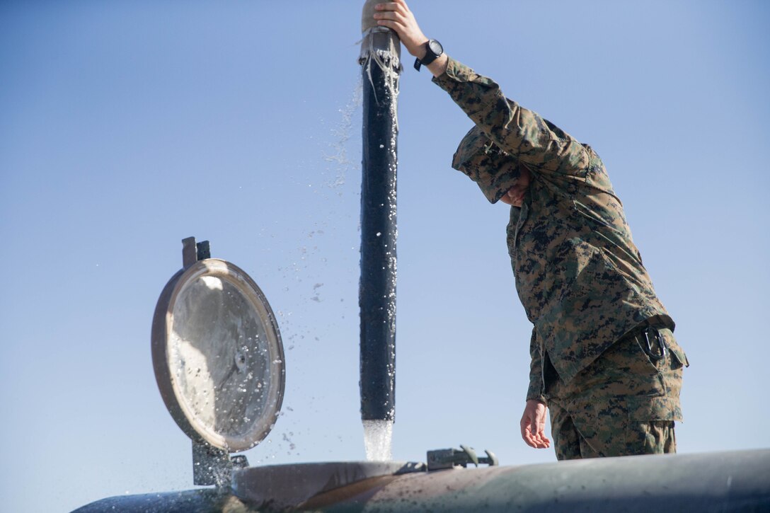 Seaman Kyler Webb, a hospital corpsman from the Naval Health Clinic, Corpus Christi, fills a water bowl, during Integrated Training Exercise 4-18 at Marine Corps Air Ground Combat Center Twentynine Palms, Calif., June 17, 2018. MCAGCC Twentynine Palms has 28 water bowls placed throughout base for training during ITX 4-18. Each bowl holds 400 gallons of water and is tested twice daily to ensure proper amounts of chlorine are within the water. (U.S. Marine Corps photo by Lance Cpl. Samantha Schwoch/released)