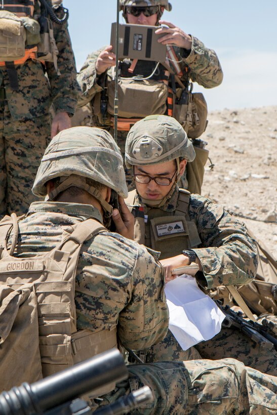 Cpl. Jonathan Azali (center), a radio operator with 3rd Air Naval Gunfire Liaison Company, Force Headquarters Group, writes the coordinates of a notional enemy during an air assault course, at Integrated Training Exercise 4-18, aboard Marine Corps Air Ground Combat Center Twentynine Palms, Calif., June 16, 2018. ITX 4-18 provides Marine Air-Ground Task Force elements an opportunity to undergo service-level competency assessments so that they can seamlessly integrate with active duty Marines in the event of a crises that requires a rapid response. (U.S. Marine Corps photo by Cpl. Dallas Johnson/Released)