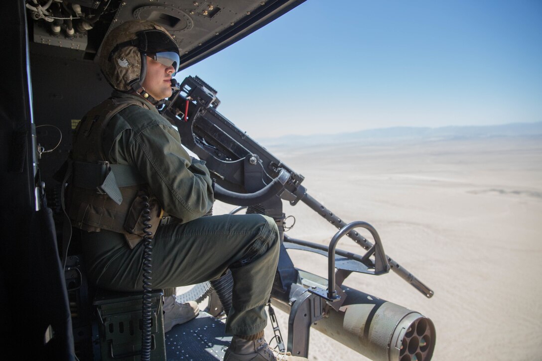 Sgt. Reyes Macedo, a helicopter crew chief with Marine Light Attack Helicopter Squadron 775, Marine Aircraft Group 41, 4th Marine Aircraft Wing, acquires a BDM, a Soviet airborne amphibious tracked infantry fighting vehicle, target while conducting a close air support mission, during Integrated Training Exercise 4-18 at Marine Corps Air Ground Combat Center Twentynine Palms, Calif., June 18, 2018. HMLA-775, also known as the “Coyotes," provided air combat element support to Marine Air Ground Task Force 23 during ITX 4-18. (U.S. Marine Corps photo by Lance Cpl. Samantha Schwoch/released