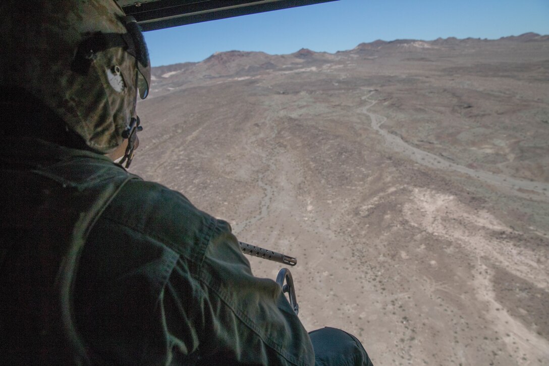 Sgt. Reyes Macedo, a helicopter crew chief with Marine Light Attack Helicopter Squadron 775, Marine Aircraft Group 41, 4th Marine Aircraft Wing, acquires a target while conducting a close air support mission, during Integrated Training Exercise 4-18 at Marine Corps Air Ground Combat Center Twentynine Palms, Calif., June 18, 2018. HMLA-775, also known as the “Coyotes”, provided air combat element support to Marine Air Ground Task Force 23 during ITX 4-18. (U.S. Marine Corps photo by Lance Cpl. Samantha Schwoch/released)