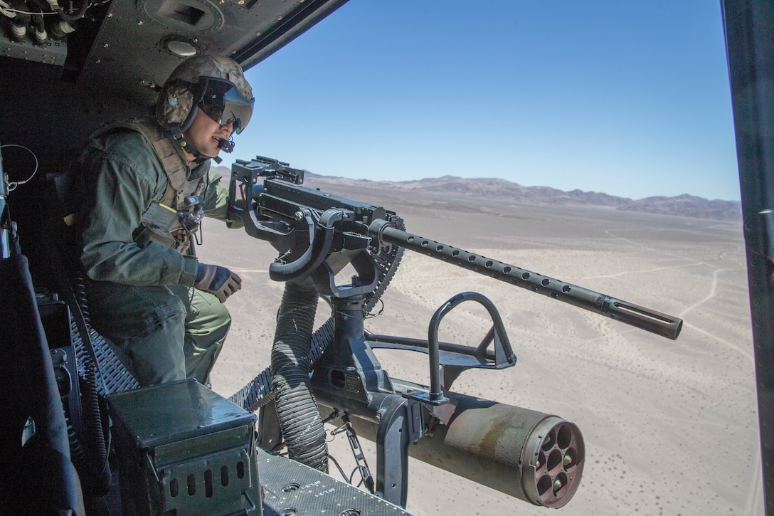 Sgt. Reyes Macedo, a helicopter crew chief with Marine Light Attack Helicopter Squadron 775, Marine Aircraft Group 41, 4th Marine Aircraft Wing, prepares to deliver close air support to Marines conducting Integrated Training Exercise 4-18 at Marine Corps Air Ground Combat Center Twentynine Palms, Calif., June 18, 2018. HMLA-775, also known as the “Coyotes”, provided air combat element support to Marine Air Ground Task Force 23 during ITX 4-18. (U.S. Marine Corps photo by Lance Cpl. Samantha Schwoch/released)