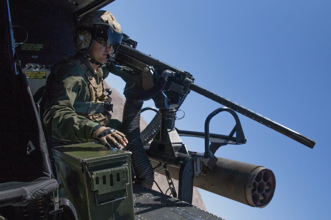 Sgt. Reyes Macedo, a helicopter crew chief with Marine Light Attack Helicopter Squadron 775, Marine Aircraft Group 41, 4th Marine Aircraft Wing, prepares to deliver close air support to Marines conducting Integrated Training Exercise 4-18 at Marine Corps Air Ground Combat Center Twentynine Palms, Calif., June 18, 2018. HMLA-775, also known as the “Coyotes”, provided air combat element support to Marine Air Ground Task Force 23 during ITX 4-18. (U.S. Marine Corps photo by Lance Cpl. Samantha Schwoch/released)