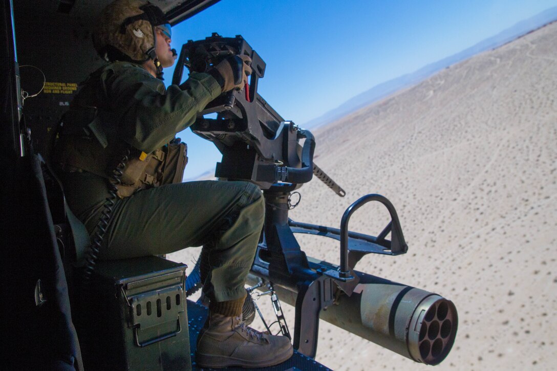 Sgt. Reyes Macedo, a helicopter crew chief with Marine Light Attack Helicopter Squadron 775, Marine Aircraft Group 41, 4th Marine Aircraft Wing, acquires a target from the Joint Terminal Attack Controller, while conducting a close air support mission, during Integrated Training Exercise 4-18 at Marine Corps Air Ground Combat Center Twentynine Palms, Calif., June 18, 2018. HMLA-775, also known as the “Coyotes," provided air combat element support to Marine Air Ground Task Force 23 during ITX 4-18. (U.S. Marine Corps photo by Lance Cpl. Samantha Schwoch/released)