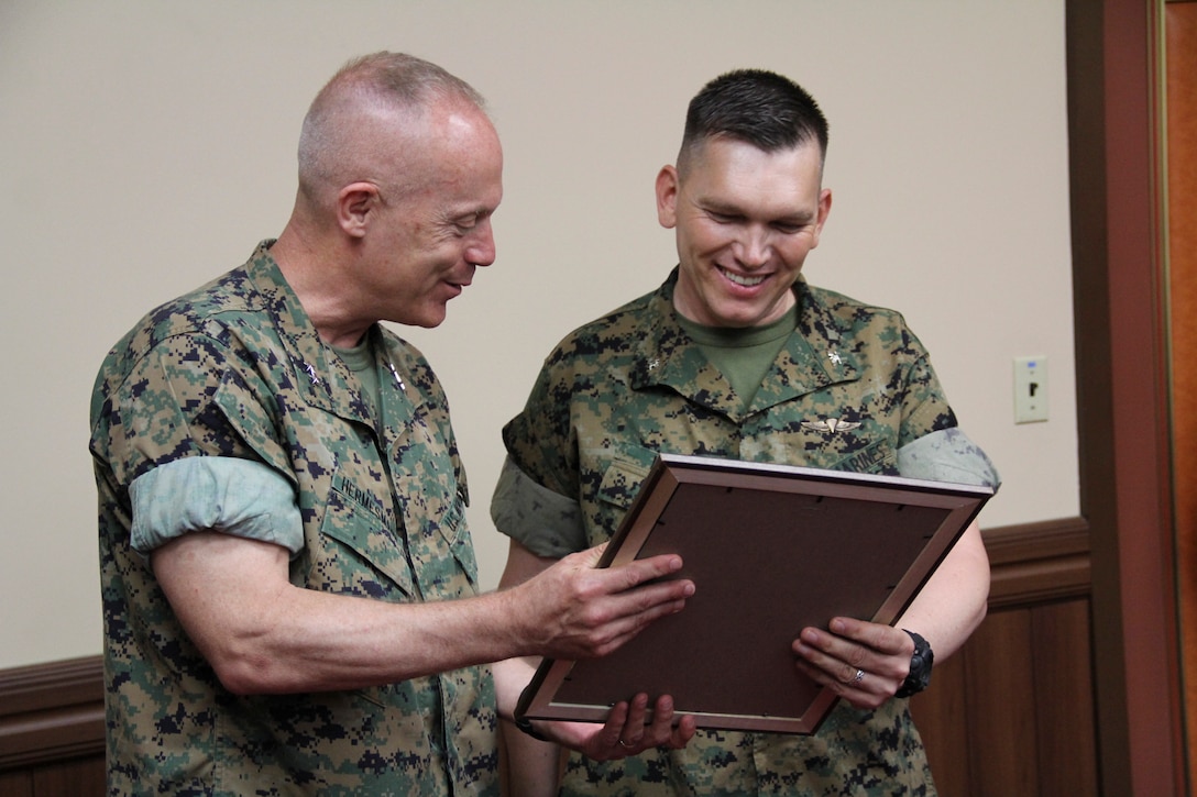 U.S. ARMY GARRISON, YONGSAN – Maj. Gen. Patrick J. Hermesmann (left), commander of U.S. Marine Corps Forces Korea, and Col. Sidney R. Welch, MARFORK G4 assistant chief of staff for logistics, admire Welch’s authorization to frock him to colonel here, June 6.  Welch was frocked to colonel under the authority of Headquarters Marine Corps and received a Meritorious Service Medal for superior performance after completion of his tour with the command. (Official U.S. Marine Corps photo by Capt. John Parry/Released)