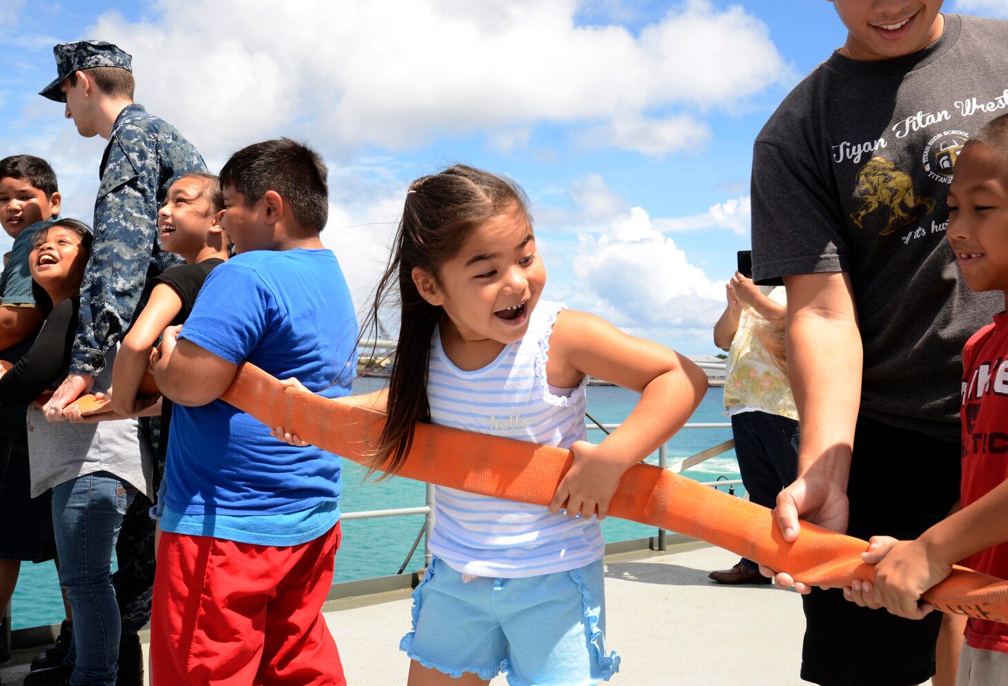 Sailors assigned to the submarine tender USS Frank Cable (AS 40) show students from various schools participating in the Piti Summer Program firefighting techniques and basic hose-handling techniques during a ship tour, June 18. Frank Cable, forward-deployed to the island of Guam, repairs, rearms and reprovisions submarines and surface vessels in the Indo-Pacific region.