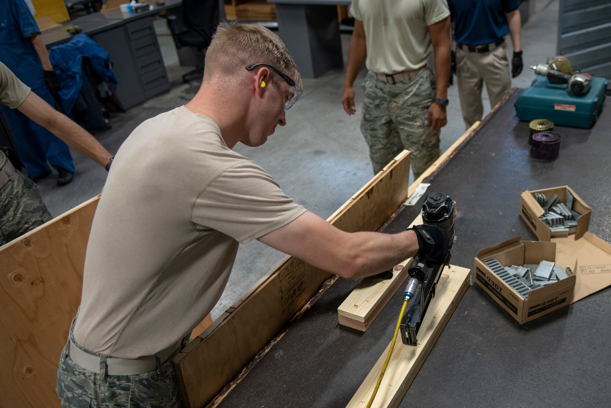 Staff Sgt. Charles Jaunich, 374th Security Forces Squadron base defense operations center controller, uses a staple gun to assemble the base of a container during the Wing Immersion Program at Yokota Air Base, Japan, June 20, 2018.