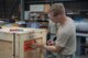 Staff Sgt. Charles Jaunich, left, 374th Security Forces Squadron base defense operations center controller, applies the shipping label to a container before shipment during a Wing Immersion program at Yokota Air Base, Japan, June 20, 2018.