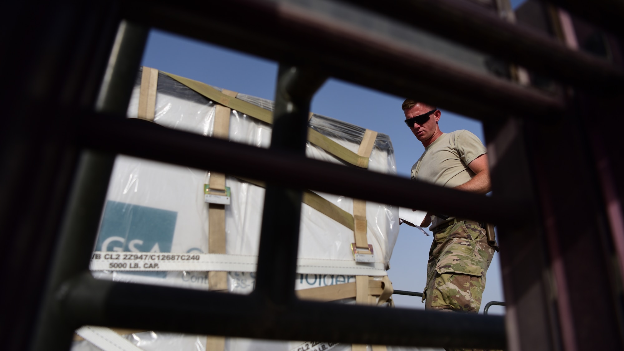 Airman 1st Class Joshua Heintzelman, 442nd Air Expeditionary Squadron aerial porter, secures a piece of cargo to a pallet aboard a K-loader, June 7, 2018, at Camp Taji, Iraq.