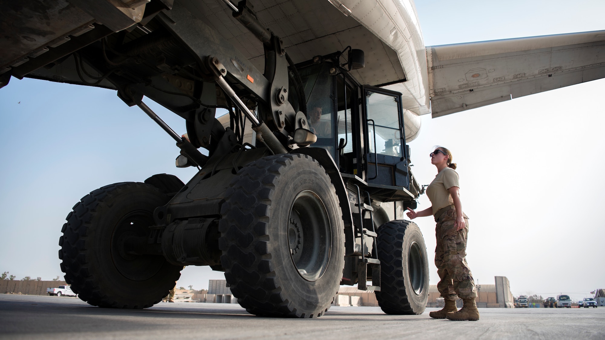 Airman 1st Class Ariel Santos, 442nd Air Expeditionary Squadron aerial porter, directs a K-loader during an aircraft unloading, June 7, 2018, at Camp Taji, Iraq.
