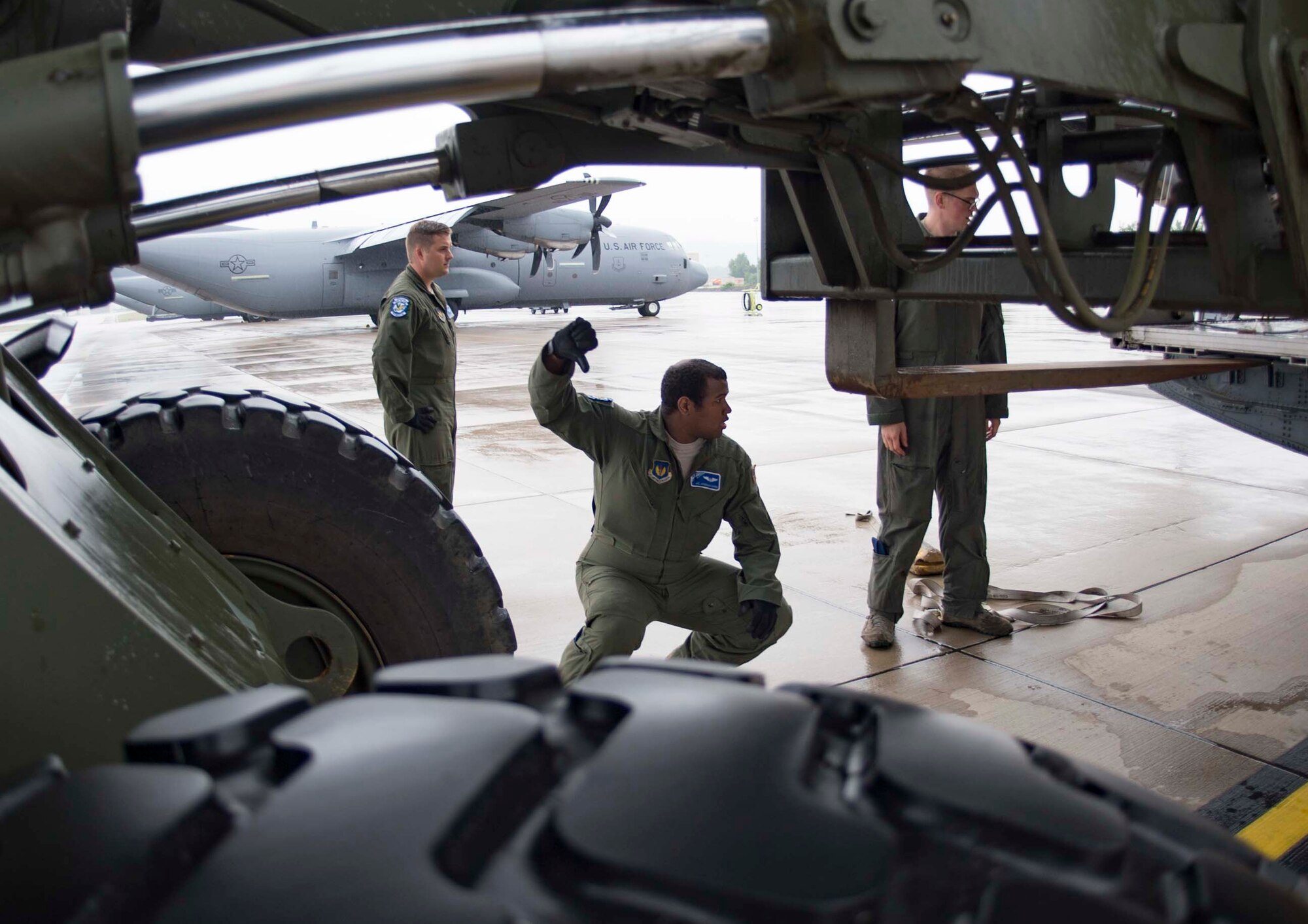 U.S. Air Force Airman 1st Class Jonathan Zapata, center, 37th Airlift Squadron C-130J Super Hercules aircraft loadmaster, directs a forklift operator loading cargo into a C-130J on Ramstein Air Base, Germany, June 12, 2018. Ramstein's loadmasters are skilled in loading and securing cargo such as vehicles and personnel inside a C-130J. (U.S. Air Force photo by Senior Airman Elizabeth Baker)