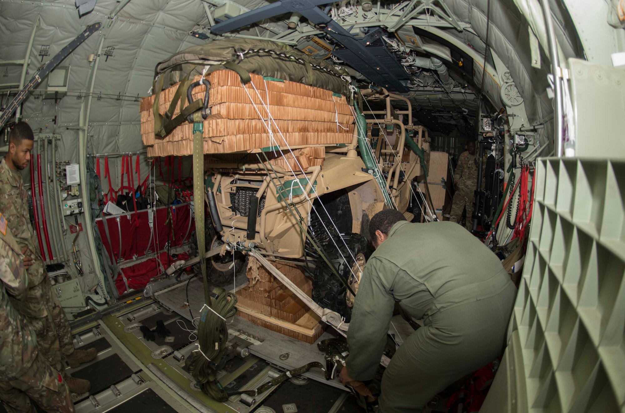 U.S. Air Force Airman 1st Class Jonathan Zapata, 37th Airlift Squadron C-130J Super Hercules aircraft loadmaster, secures a vehicle for transport on a C-130J on Ramstein Air Base, Germany, June 12, 2018. Loadmasters calculate proper weight distribution of cargo, ensuring the aircraft is properly balanced so the pilots can fly it safely. (U.S. Air Force photo by Senior Airman Elizabeth Baker)