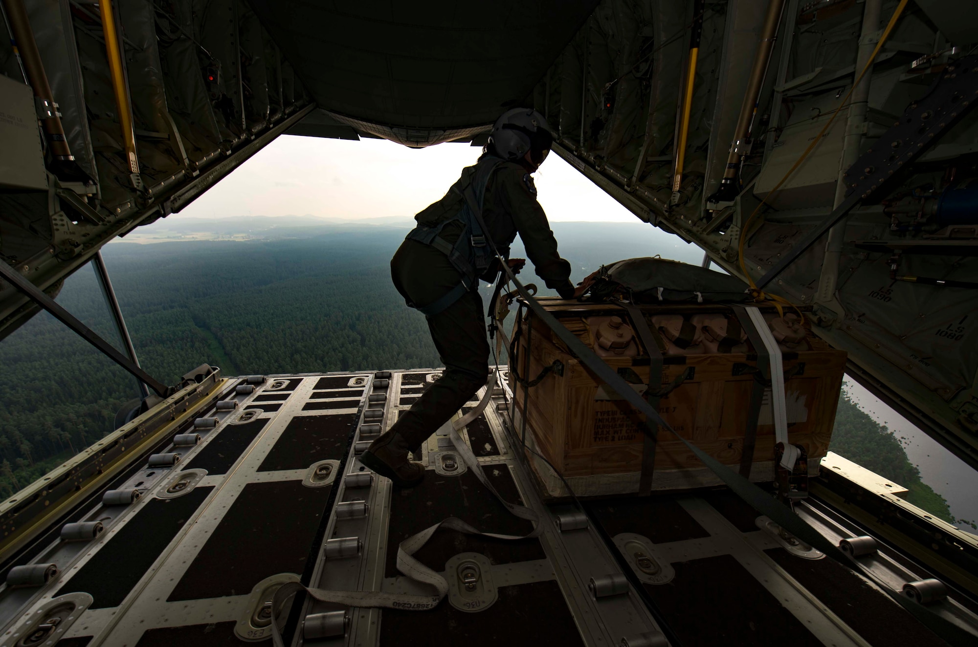U.S. Air Force Senior Airman Vanessa Soriano-Cervantes, 37th Airlift Squadron C-130J Super Hercules aircraft loadmaster, prepares a low-cost, low-altitude bundle for air drop over an airfield in Germany, June 12, 2018. Air drops can consist of tanks, helicopters, food and medical supplies, making 37th AS loadmasters a key to supporting missions in deployed locations. (U.S. Air Force photo by Senior Airman Elizabeth Baker)