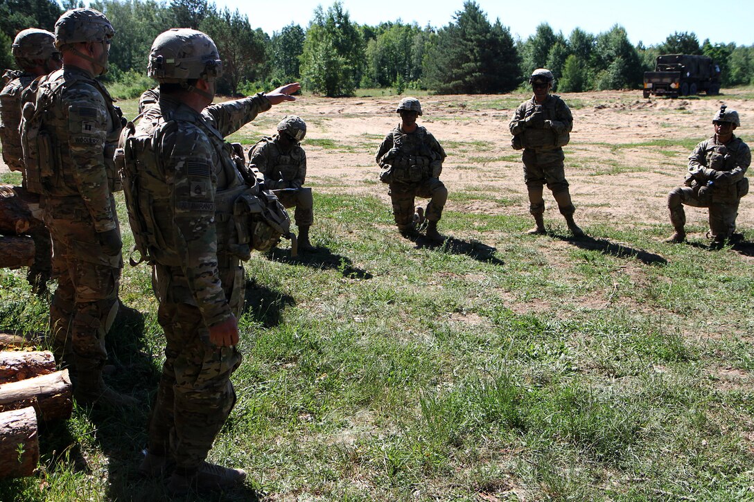 Soldiers discuss and plan how they will conduct an upcoming howitzer live-fire training exercise.