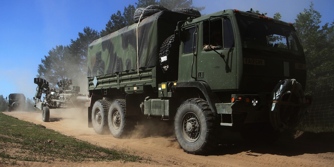 Soldiers maneuver their vehicles and howitzer to firing locations.