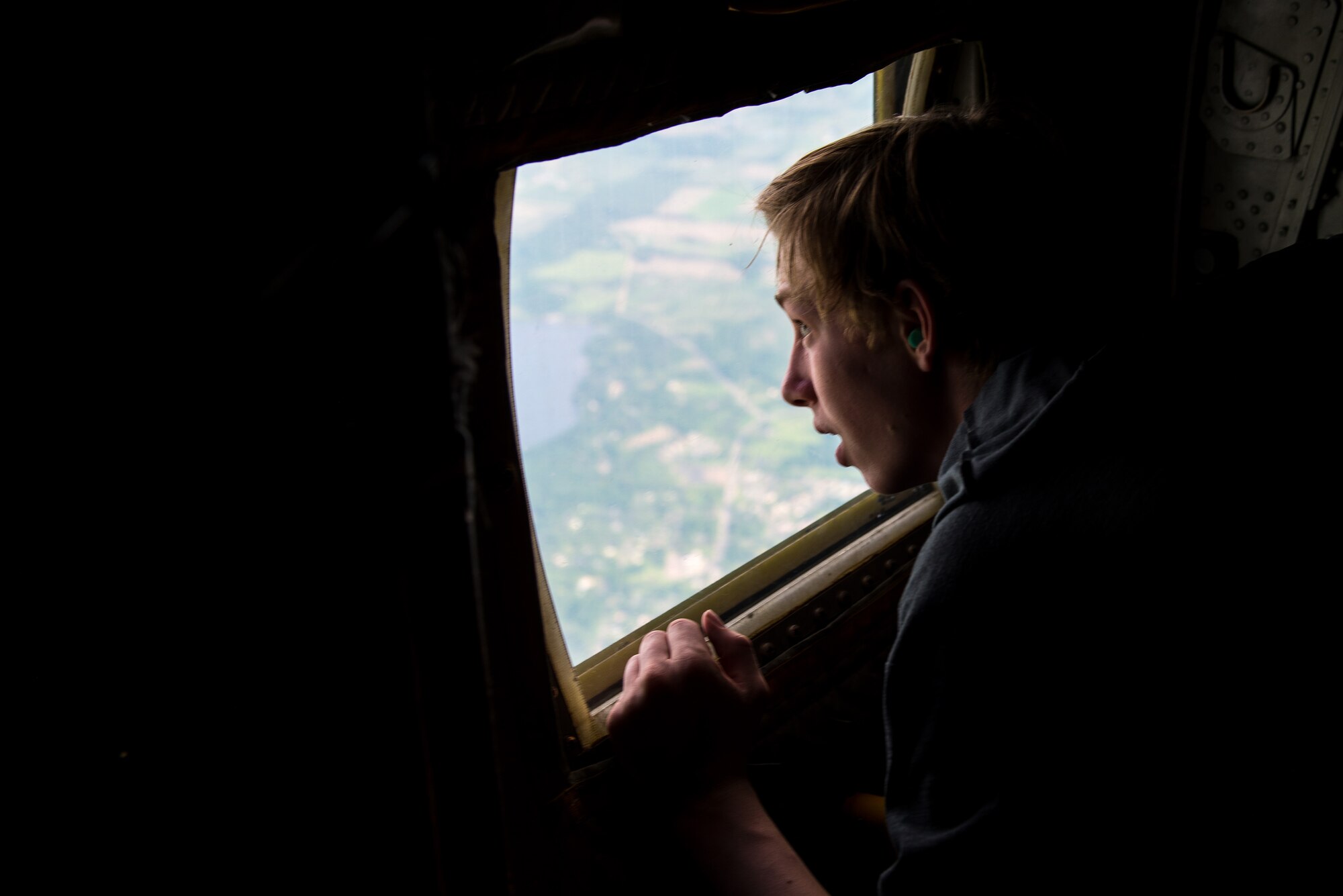 A participant in the Minnesota Aviation Career Education Camp peers outside the window at the Minnesota landscape June 14, 2018. Students have the opportunity to fly in a helicopter, fly an airplane with the help of a flight instructor, ride along in a C-130 flight at the 934th Airlift Wing. (U.S. Air Force photo by Master Sgt. Eric Amidon)