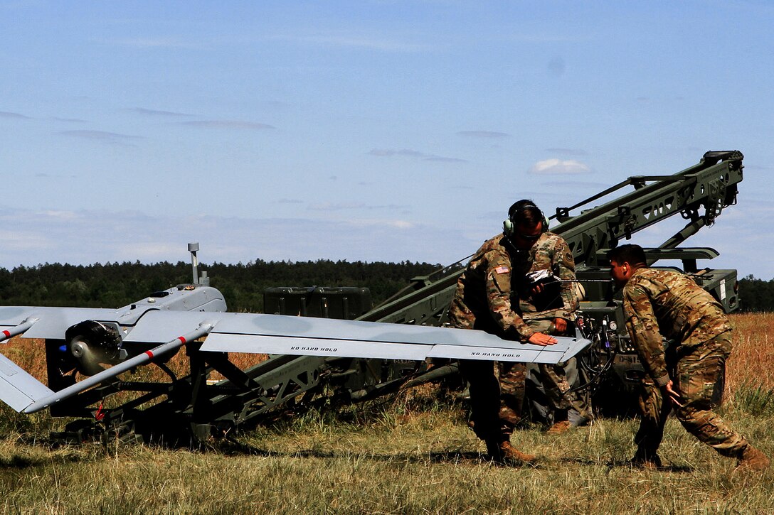 Soldiers conduct pre-flight checks on an unmanned aerial vehicle shadow drone.
